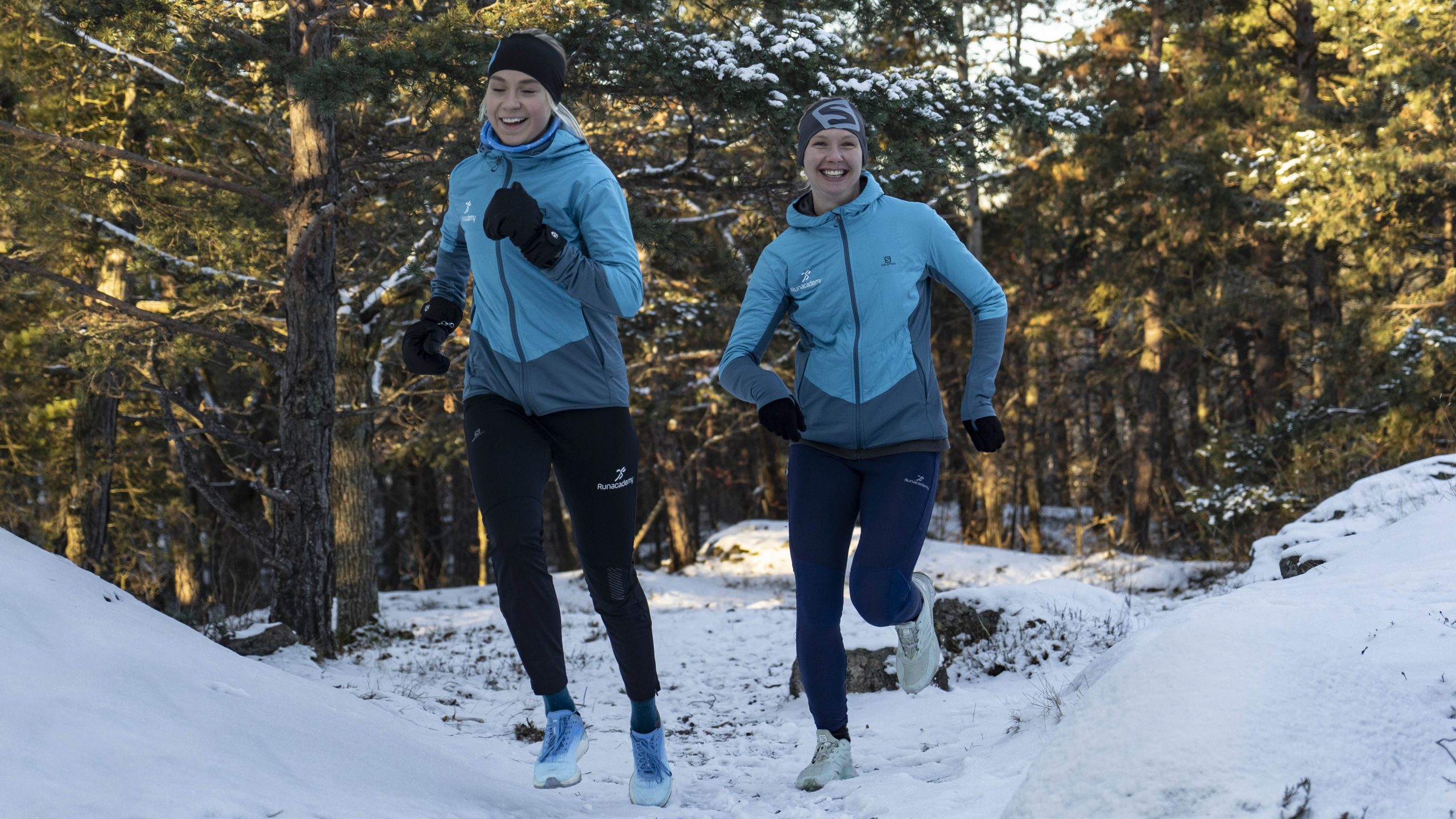 Två tjejer springer i snön