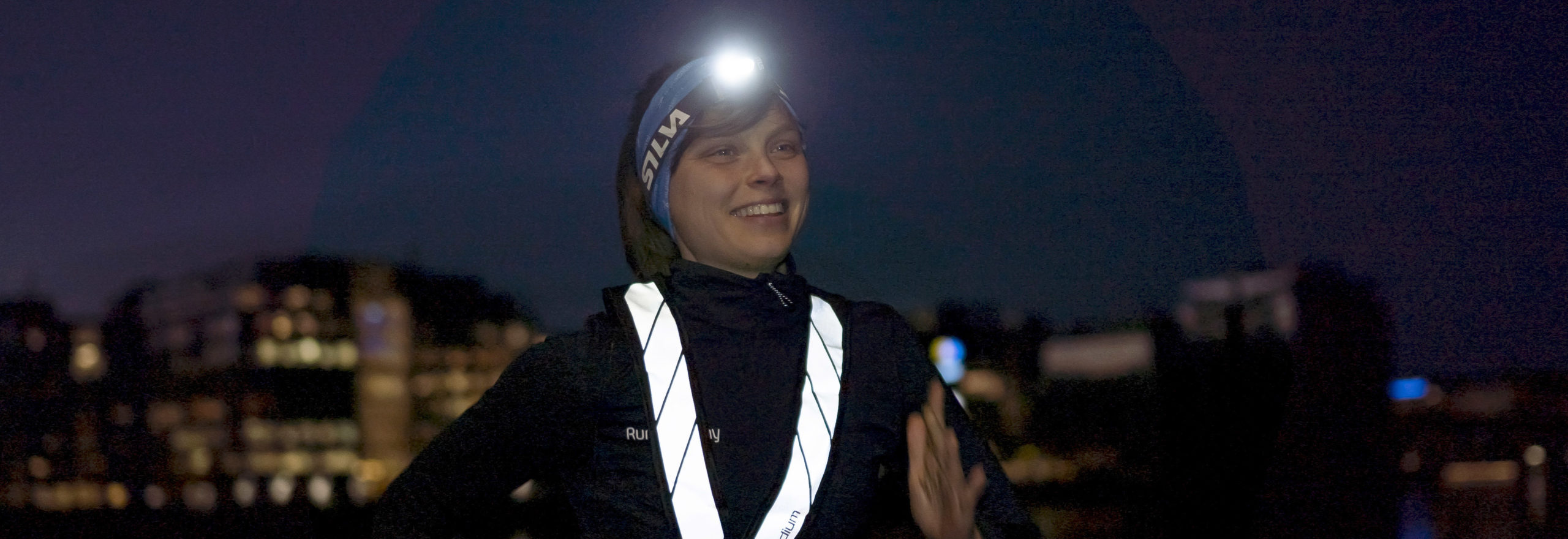 tjej springer i mörkret med lampa