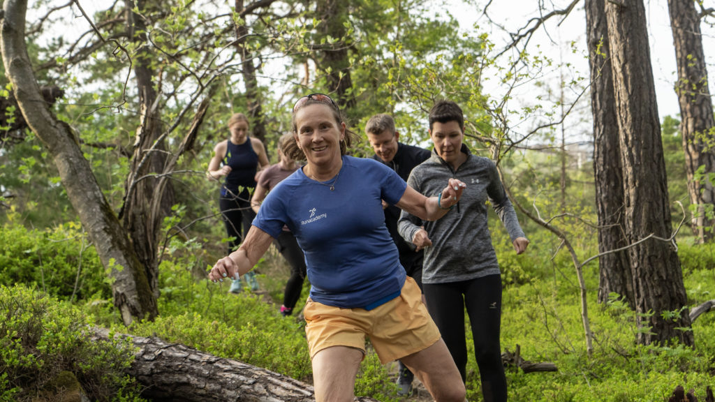 Löpargrupp springer tillsammans i skogen